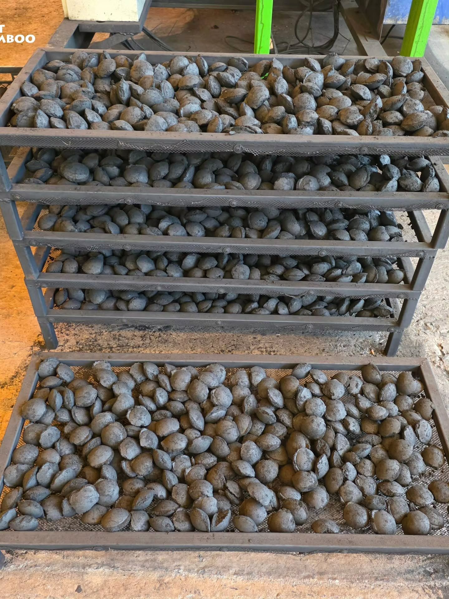 Charcoal briquettes drying on multi-tier racks