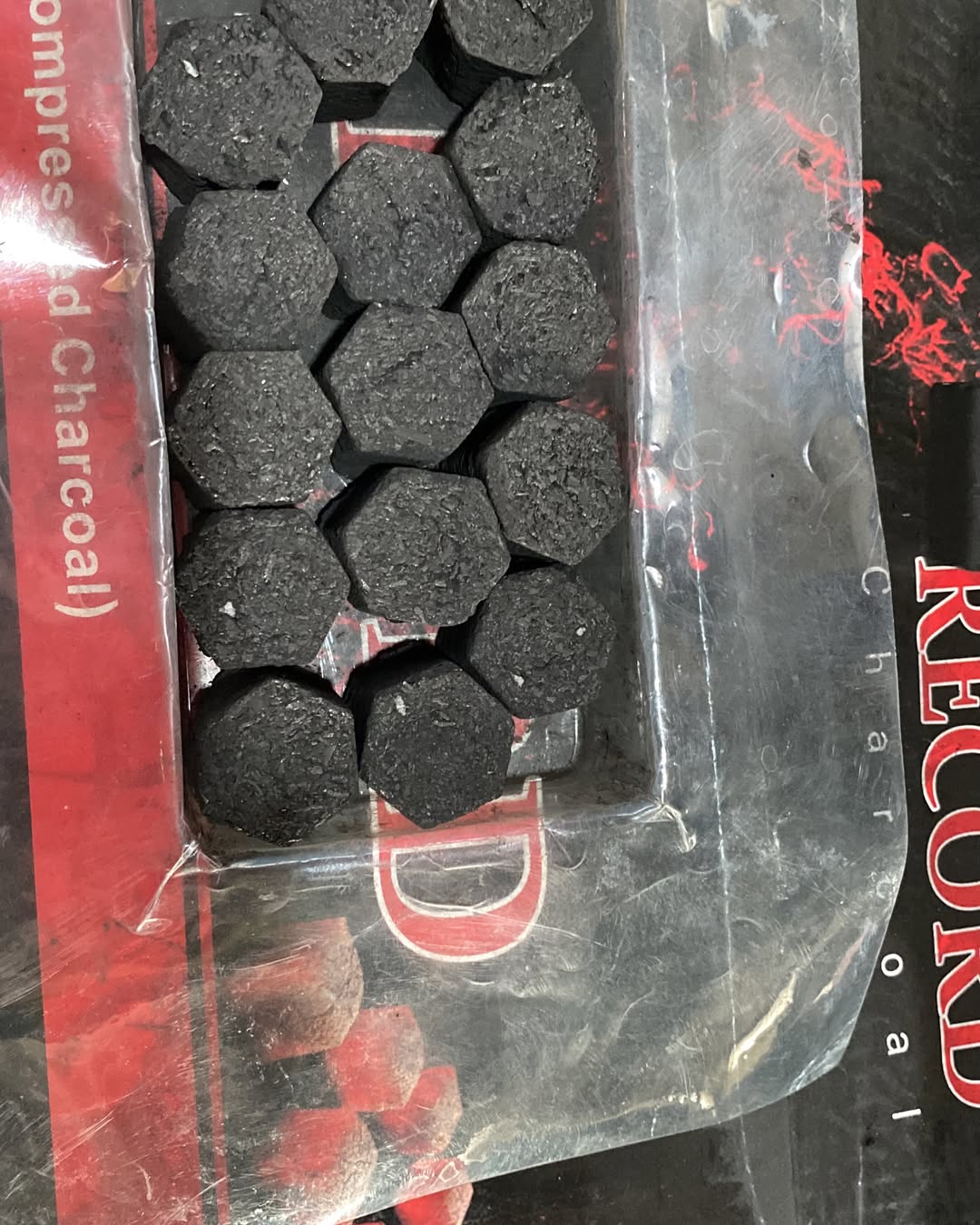 Hexagonal compressed charcoal briquettes packed in a retail bag